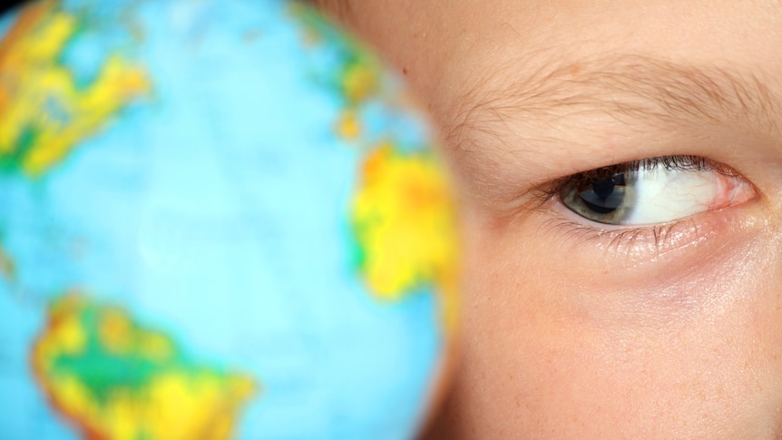 Boy looking at a globe of the world