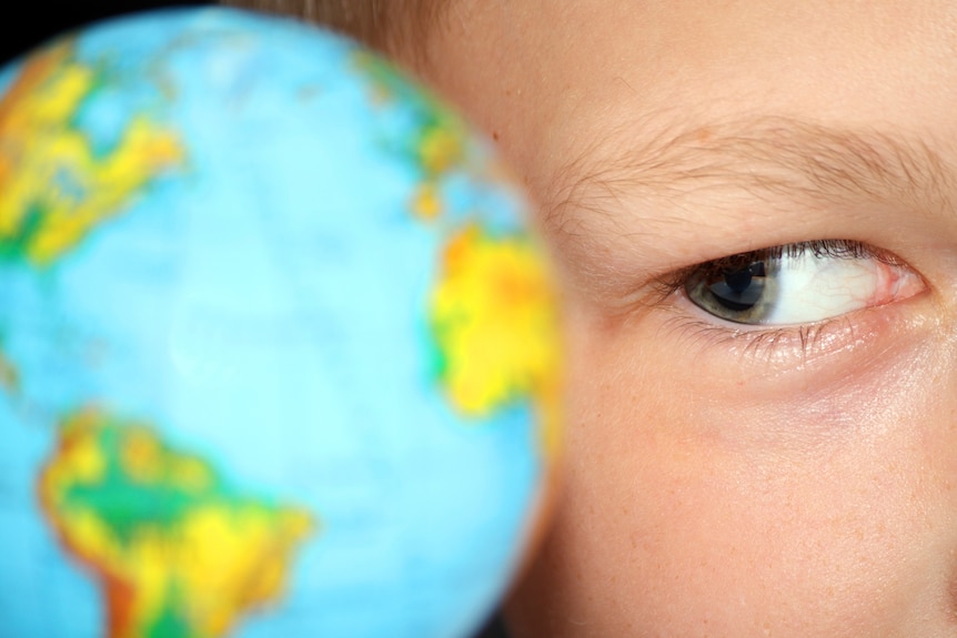 Boy looking at a globe of the world