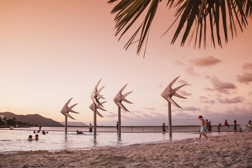 A man-made beach and swimming pool at sunset