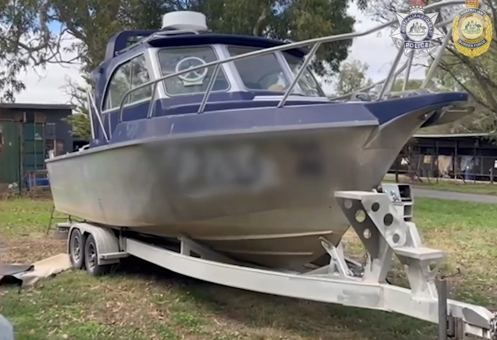 Un barco sobre un remolque sentado sobre el césped.