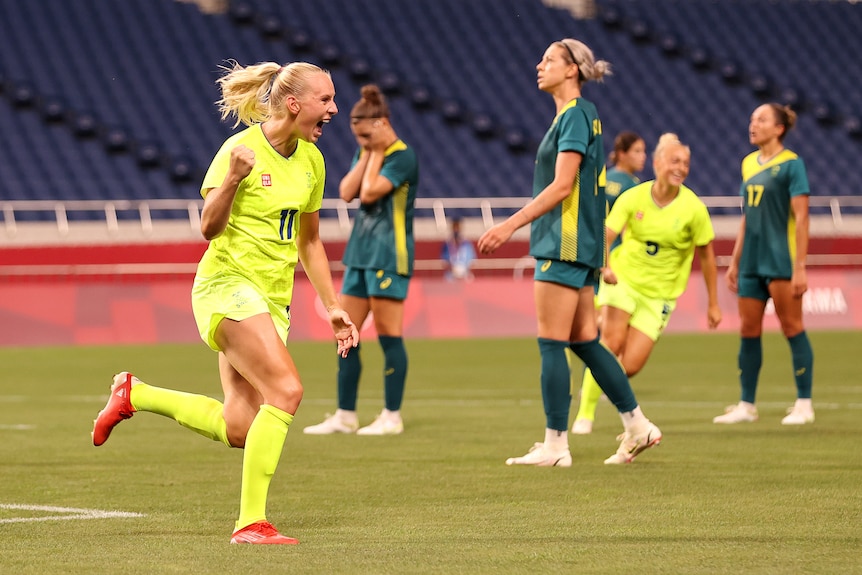 Stina Blackstenius pumps her fist as Australian players look sad.
