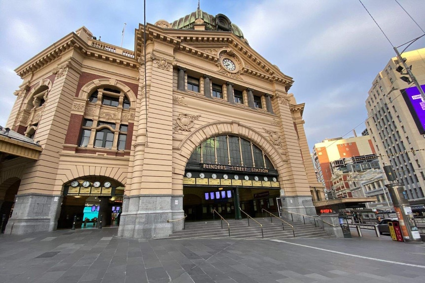 The ornate sandstone and bluestone entrance to a train station appears completely empty without anyone in sight.