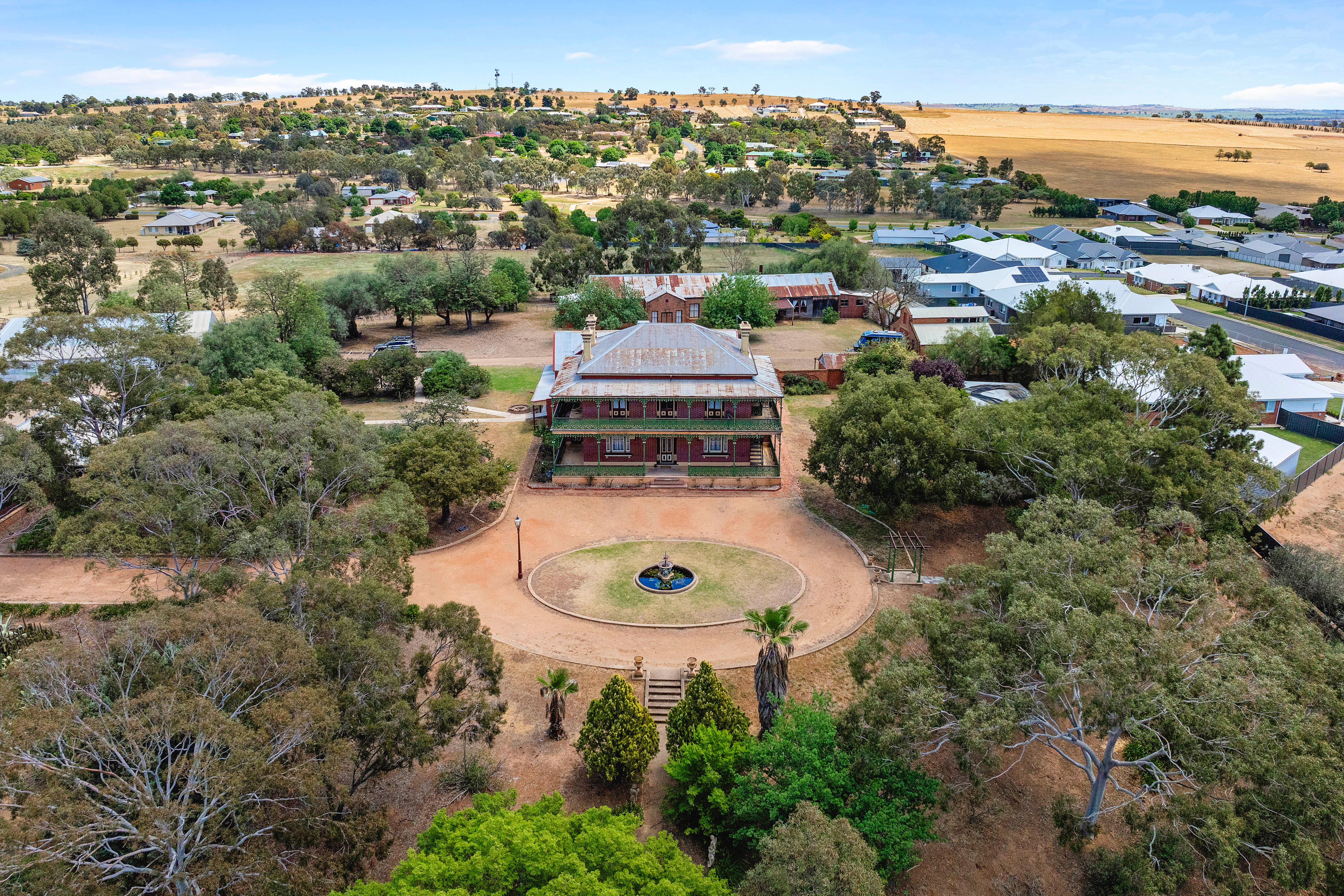 Imagem de uma casa de fazenda em estilo vitoriano tirada de cima por um drone.
