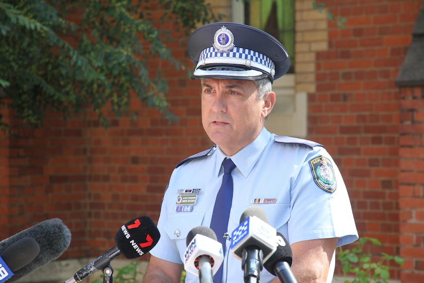 nsw police officer standing in front of mic