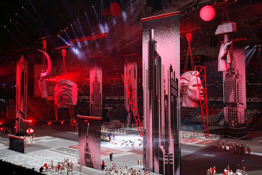 City scene with images of hammers and sickles is shown at an Olympics opening ceremony in Russia.