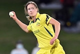 An Australian female professional cricketer holds a ball in her right hand.