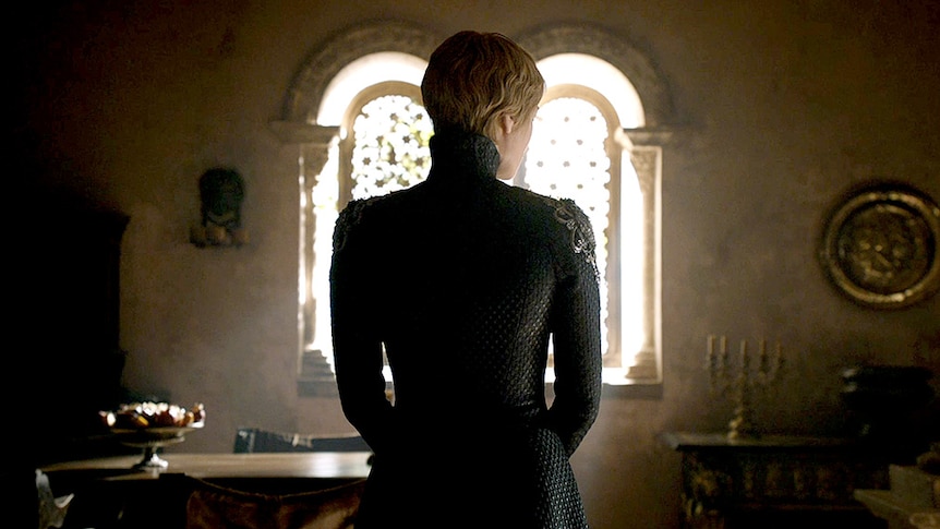 Cersei Lannister is silhouetted by a medieval-style window