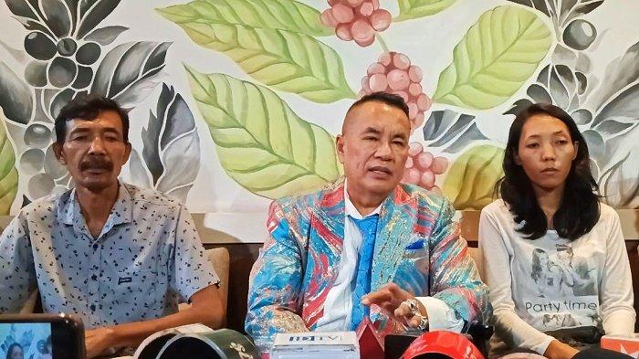 Three people, one of whom on the right side is a woman sitting and facing the camera.