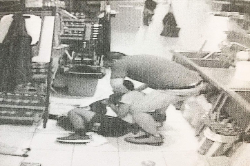 CCTV still of Brisbane kebab shop owner Onur Erkan holding 15-year-old employee on ground during assault