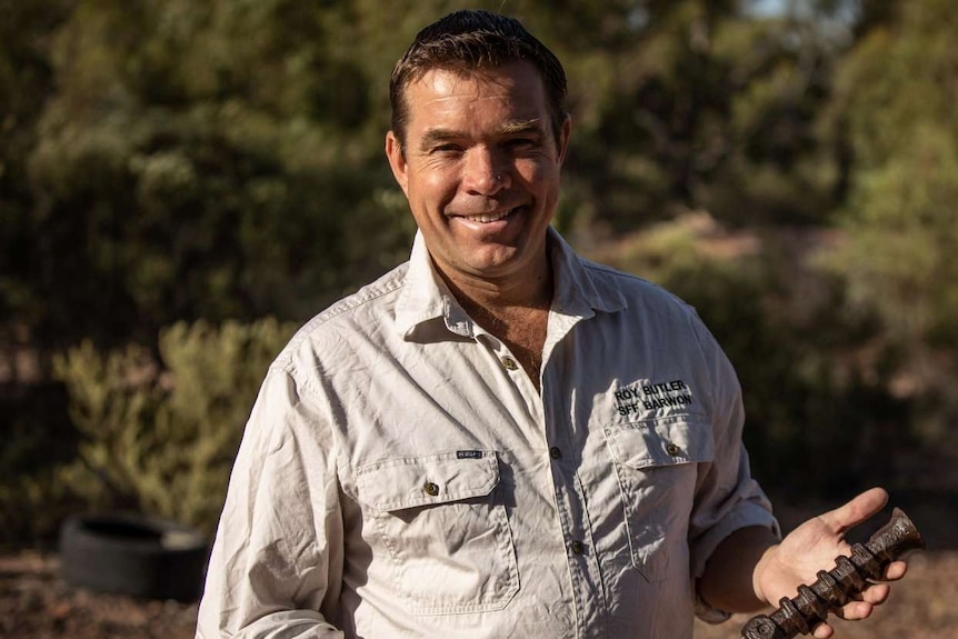 A man standing in front of the bush.