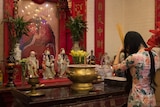Kimmy Dao praying at temple alter