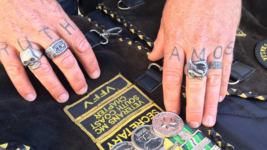 Derek Pyrah's tattooed fingers rest near his three service medals.
