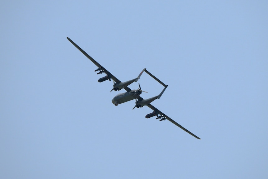 An image of a black drone in flight. 