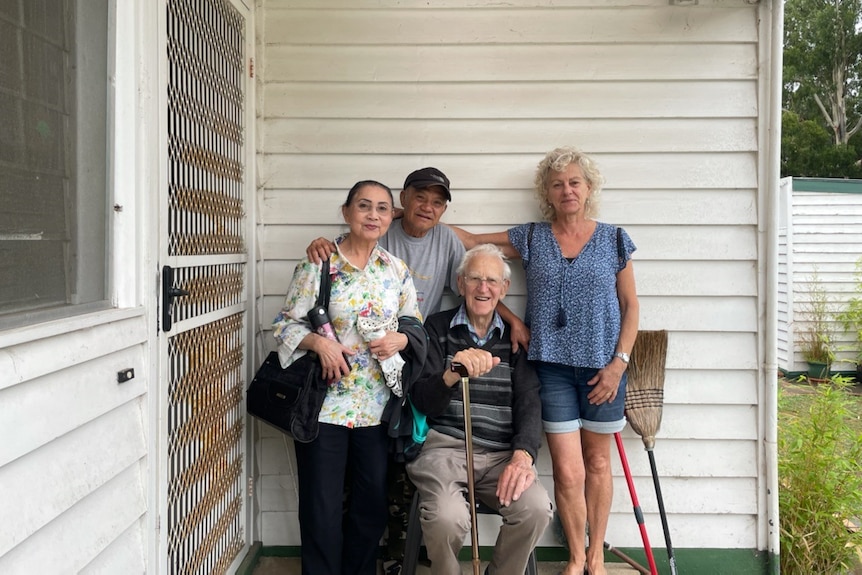 Anne and Nahn stand with Ted Oliver and Pauline Oliver-Snell on the porch of a white house.