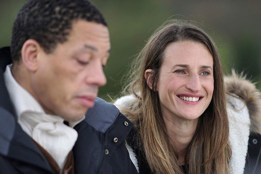 A man and woman, talking and smiling.