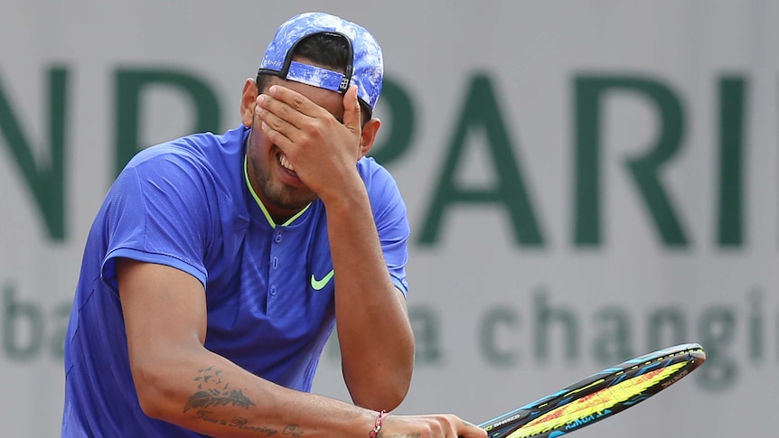 Nick Kyrgios covers his eyes after missing a shot.