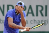 Nick Kyrgios covers his eyes after missing a shot.