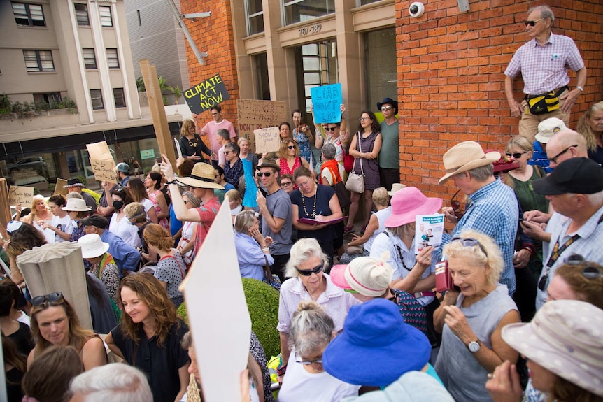 A crowd outside Dave Sharm's electoral office hold a climate change action vigil
