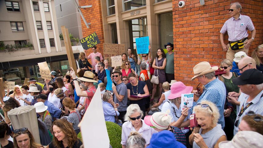 A crowd outside Dave Sharm's electoral office hold a climate change action vigil