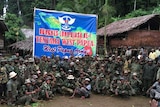West Papua separatist groups gather below an army banner.