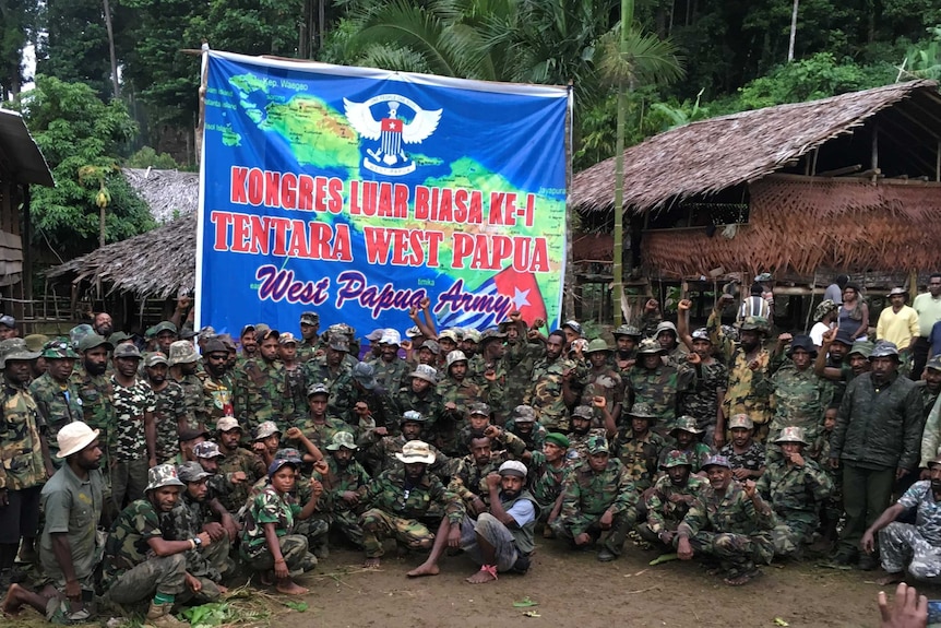 West Papua separatist groups gather below an army banner.