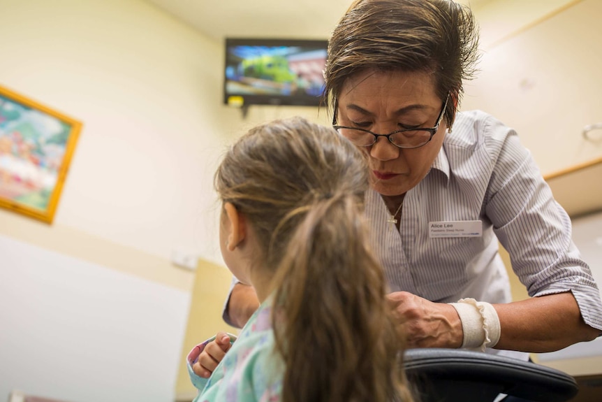 Nurse Alice Lee wires up Melina for sleep study