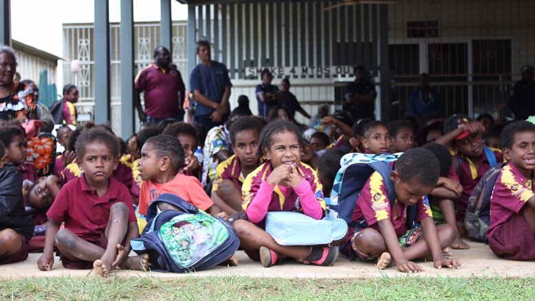 Smiling children on Saibai island in the Torres Strait sitting on the ground in July 2017