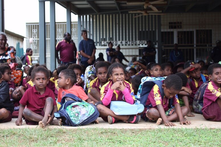 Smiling children on Saibai island in the Torres Strait sitting on the ground in July 2017