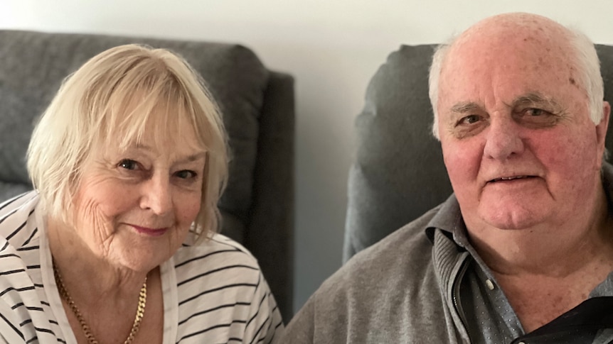 An older man and woman pose for a photo. 