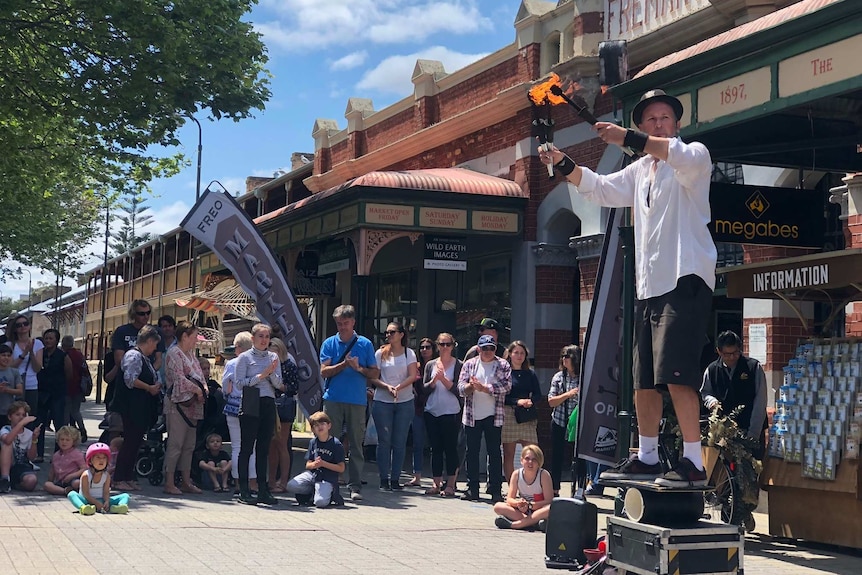 Busker Scott Chocolate performs a balancing act with firesticks