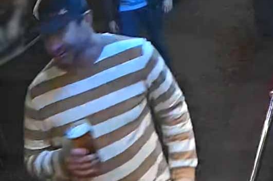 CCTV footage shows a man in a stripy jumper and cap holding a beer outside.