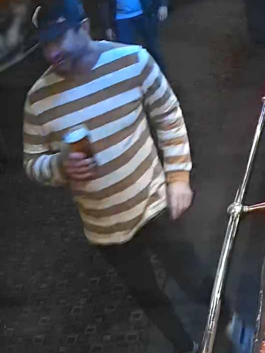 CCTV footage shows a man in a stripy jumper and cap holding a beer outside.