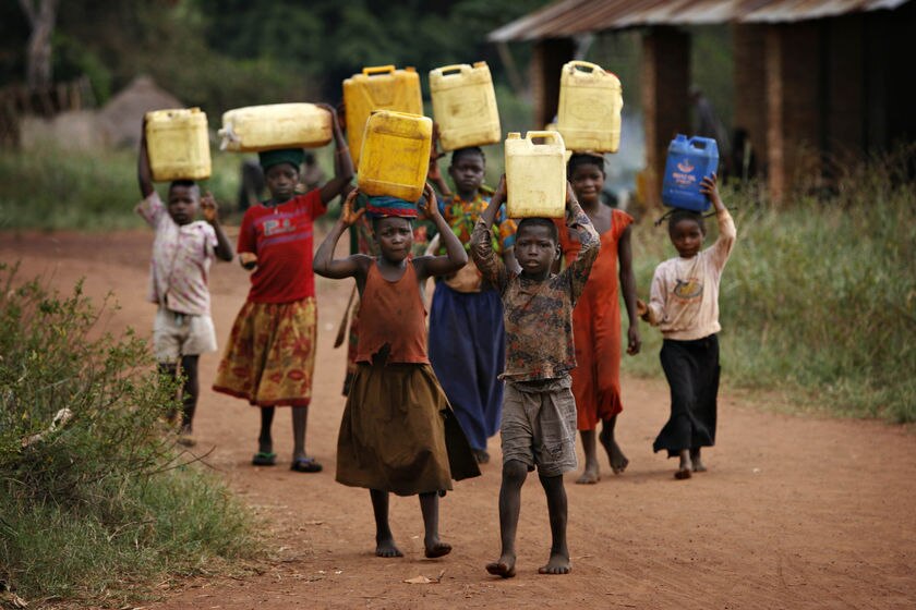 Children carry containers of water in the village of Bangadi in northeastern Congo