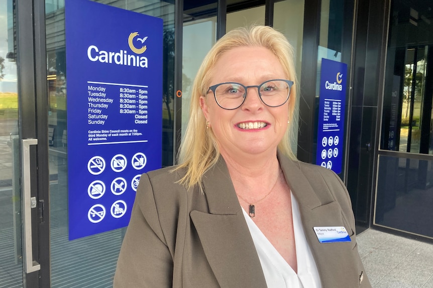 A blonde woman with glasses outside a Cardinia council sign