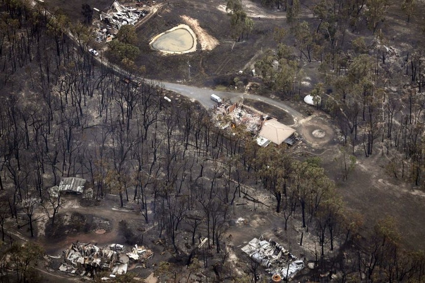 The remains of houses destroyed by bushfires line a street in the town Kinglake