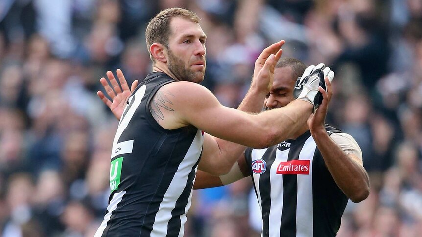 Travis Cloke of the Magpies is congratulated by Travis Varcoe