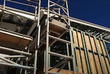 Building with frame, roof and scaffolding.