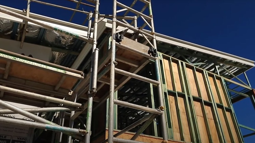 Building with frame, roof and scaffolding.