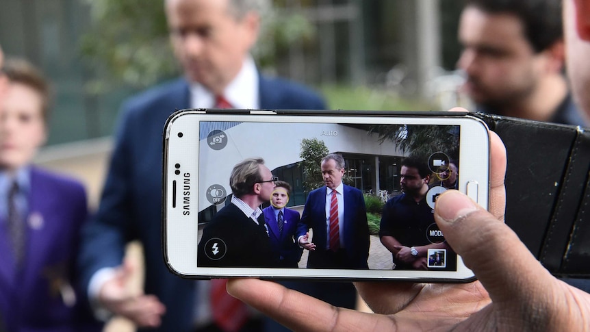 Bill Shorten is seen on a smartphone speaking with students at Melbourne University.