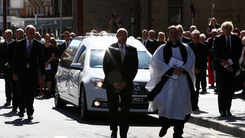 Mourners follow Vanessa Goodwin's hearse after her funeral service in Hobart.