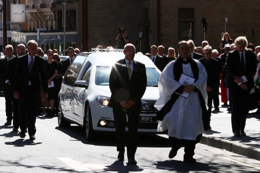 Mourners follow Vanessa Goodwin's hearse after her funeral service in Hobart.