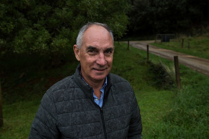 Mark Barnett from the Agri Energy Alliance stands outside by a dirt driveway.