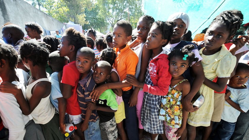 Haitian earthquake victims line up to get food donations at a refugee camp in Port-au-Prince
