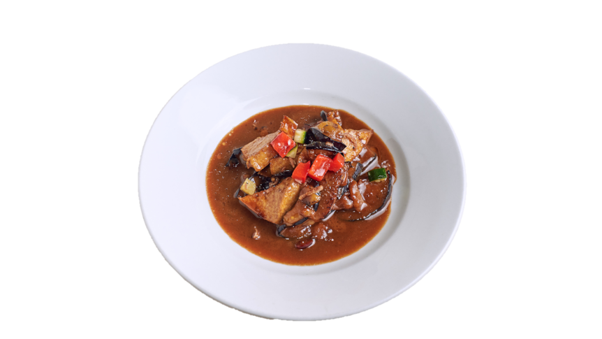Eggplant in spicy sweet soy and coconut milk in white dish.