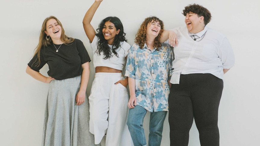 Four people standing against a wall in a story about the complex nature of body confidence.