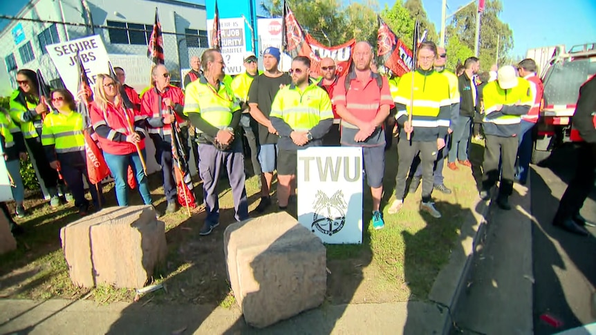 Workers with signs taking strike action.