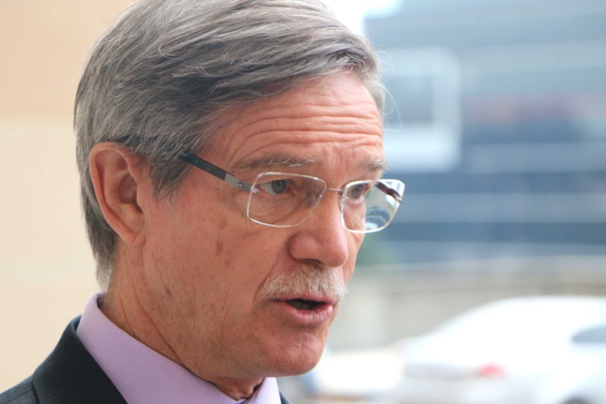 A close-up image of former WA Treasurer Mike Nahan, with purple collar and green tie.