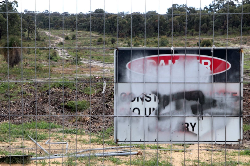 The Roe 8 site with danger sign in foreground and the levelled swathe of bush in the background.