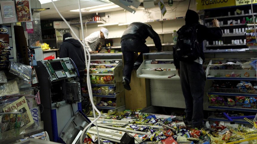 Looters rampage through a convenience store in Hackney, east London. (Reuters: Olivia Harris)
