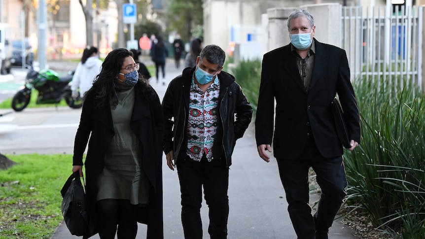 Mark James (right), son of Maria James departs from the Coroners Court of Victoria in Melbourne, wearing a mask.